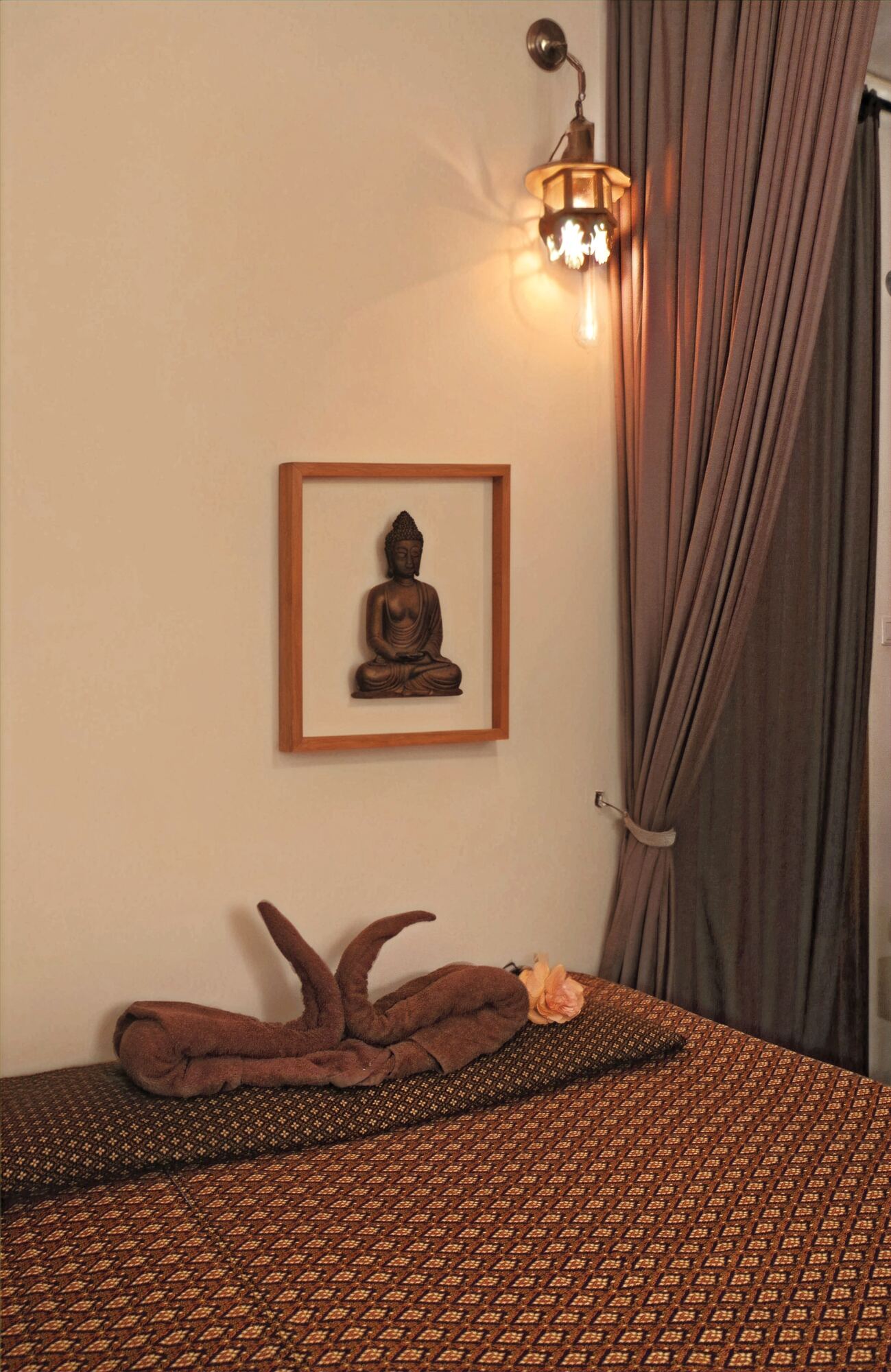 Behandelkamer met Thaise matras, boeddhabeeld en warm licht